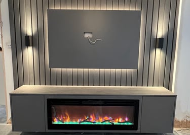 Modern media wall with a mounted TV area, built-in electric fireplace, and LED accent lighting on a ribbed panel background.