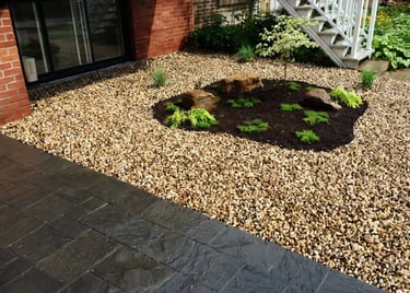 Platebande en pierres de rivière avec roches, paillis et plantes décoratives par M2 Paysage