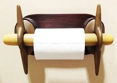 Front view of a toilet paper holder made of two brass cleats.