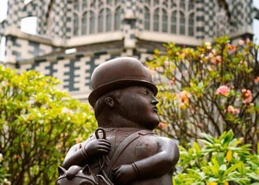 The bronze Horse and Rider Fernando Botero sculpture sits before the checkered facade of the Museum of Antioquia in Medellin.