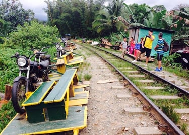 Motorcycle-powered bamboo trains parked on a railway track in the Colmbian jungle.