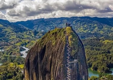 Aerial view of the massive Rock of Guatapé with zigzagging stairs and lush Colombian scenery.