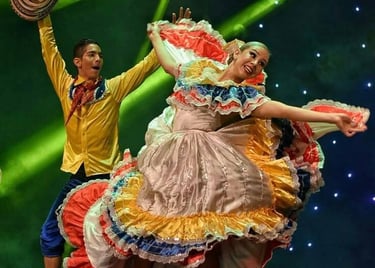 Couple performing a traditional Colombian Cumbia dance in vibrant folkloric costumes under green stage lights.