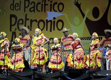 Afro-Colombian dancers in colorful traditional dresses performing at the Petronio Alvarez festival.