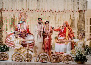 Traditional Kerala wedding ceremony featuring a bride, groom, and Kathakali dancers on a decorated stage.