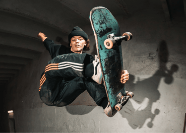 a man in a black jacket and a skateboarder in the air