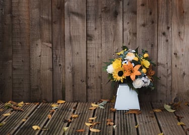a vase with flowers in a vase on a wooden floor