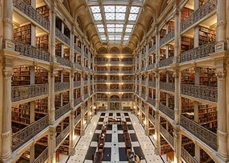 The George Peabody Library featuring five tiers of cast-iron balconies and a massive skylight.