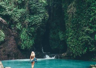 a woman standing on a rock in a river