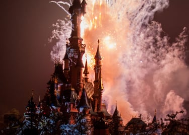 Espectáculo nocturno de fuegos artificiales iluminando el cielo sobre el Castillo de Disney