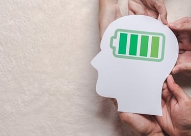 a person holding a paper cutout of a head with a battery