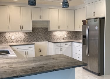 a kitchen with white shaker cabinets