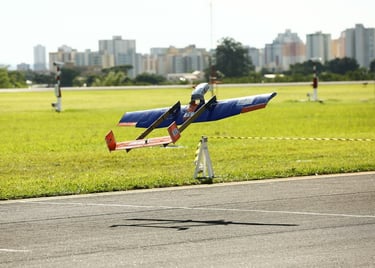 Monoplano com fuselagem interna, asa azul, empenagem U laranja. Decolando