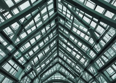 Close-up of modern glass buildings with intricate architectural lines against a cloudy London sky.