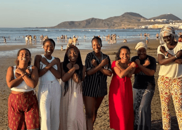 un grupo de mujeres afro posando para la foto en una playa