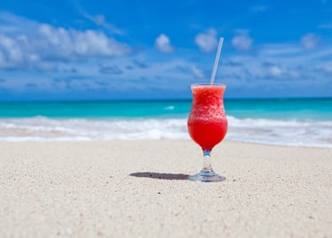 a glass of red wine on the beach