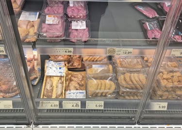 Das Bild zeigt ein Kühlregal mit sehr viel billigem und abgepacktem Fleisch