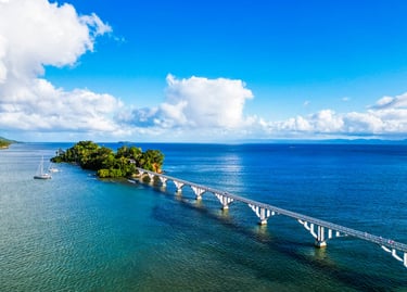 Samaná bridge over blue ocean with sailboats and tropical island in Dominican Republic