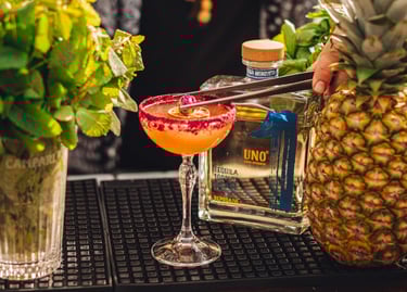 tequila cocktail fruityon a bar with a bottle of uno tequila reposado - premium tequila reposado