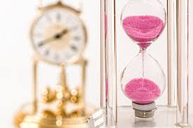 a clock with pink sand inside of it