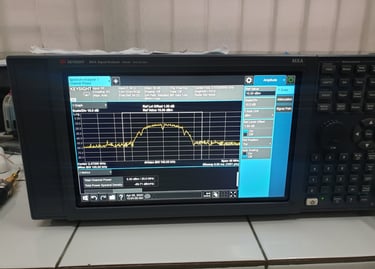A Keysight MXA signal analyzer displaying a frequency spectrum graph and channel power data on its digital screen.