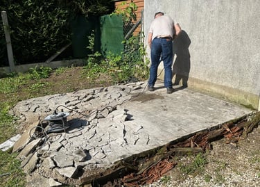 homme entrain de cassé du béton avec un marteau piqueur.