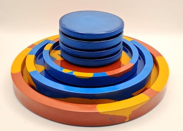 Handmade colorful gypsum nesting trays and coasters in blue, yellow, and red marble patterns.