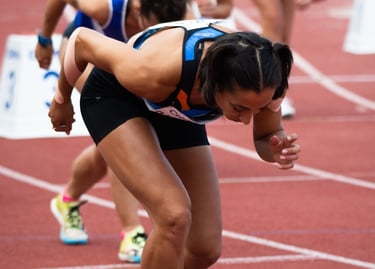 a woman in a blue and white outfit is running on a track