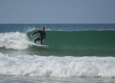 a man in a wetsuit surfing on a wave