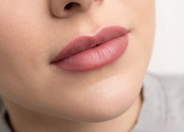 Close-up of a woman's lips showing natural pink permanent makeup lip blush results.