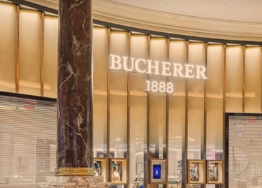 Luxury Bucherer 1888 jewelry and watch store facade with marble pillars and gold accents.