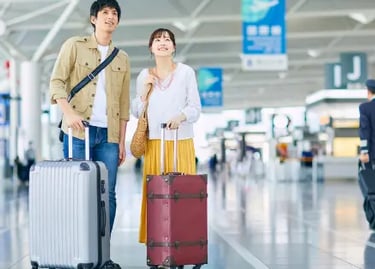 A happy couple with suitcases standing in a modern airport terminal for international travel.