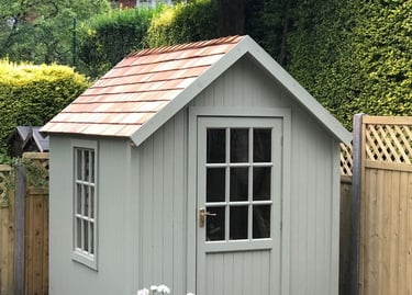 A small shed with a window and a yard.