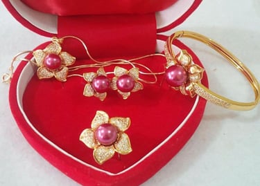 a heart shaped box with a pair of rings and a pair of earrings