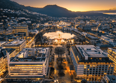 Aerial view of Bergen city center at twilight featuring the Lille Lungegårdsvannet lake and Christmas market.
