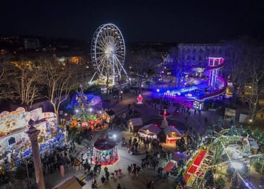 Aerial view of a festive Christmas market at night with a glowing Ferris wheel and carnival rides.
