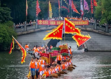 Traditional Chinese dragon boat race with participants rowing under a stone bridge decorated with red flags.