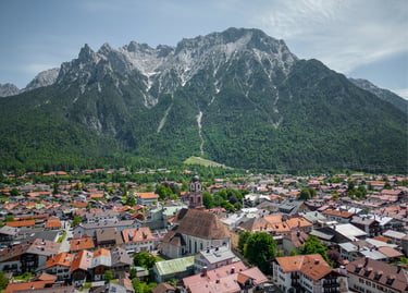 Aerial view of Mittenwald village with red roof houses and the Karwendel mountains in the Bavarian Alps.