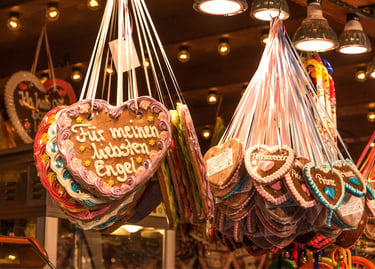 Traditional decorated German gingerbread heart cookies hanging at a festive Christmas market stall.