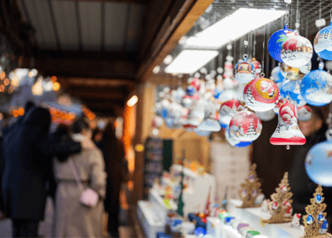 Colorful hand-painted glass ornaments hanging at a European Christmas market stall.