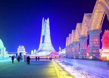 Illuminated ice sculptures and towers at the Harbin International Ice and Snow Festival at night.