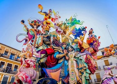A colorful Las Fallas monument featuring ornate, towering sculptures during the festival in Valencia, Spain.