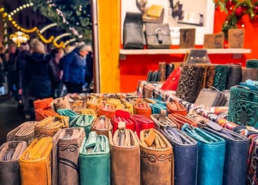 Handmade leather wallets and purses displayed at a festive outdoor Christmas market stall.