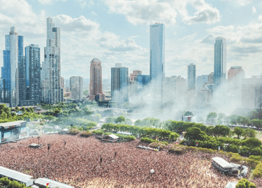 Aerial view of a crowded music festival in Grant Park with the Chicago skyline in the background.