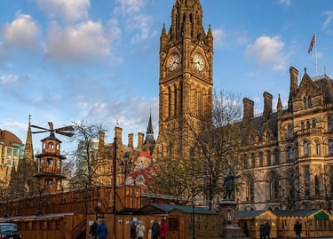 Manchester Town Hall and Christmas Market stalls featuring a large Santa and gothic clock tower.