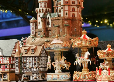 Handcrafted German Christmas market miniature castle, timber-frame houses, and rotating carousel figurines.