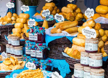 Display of traditional Polish Oscypek smoked sheep cheese and cranberry jam at a Zakopane market stall.