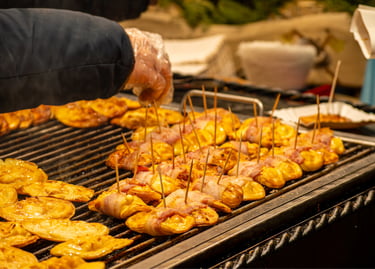 Grilled oscypek smoked sheep cheese wrapped in bacon at a traditional Polish Christmas market stall.