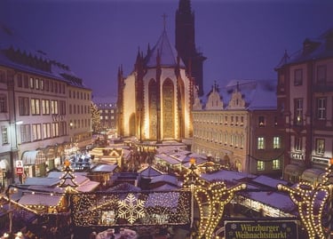 Illuminated stalls at the Wurzburg Christmas Market at night with the Marienkapelle church in Germany.