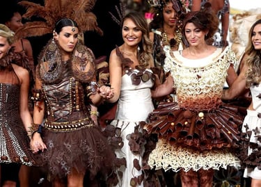 Models walking a runway in intricate chocolate dresses and edible fashion couture.